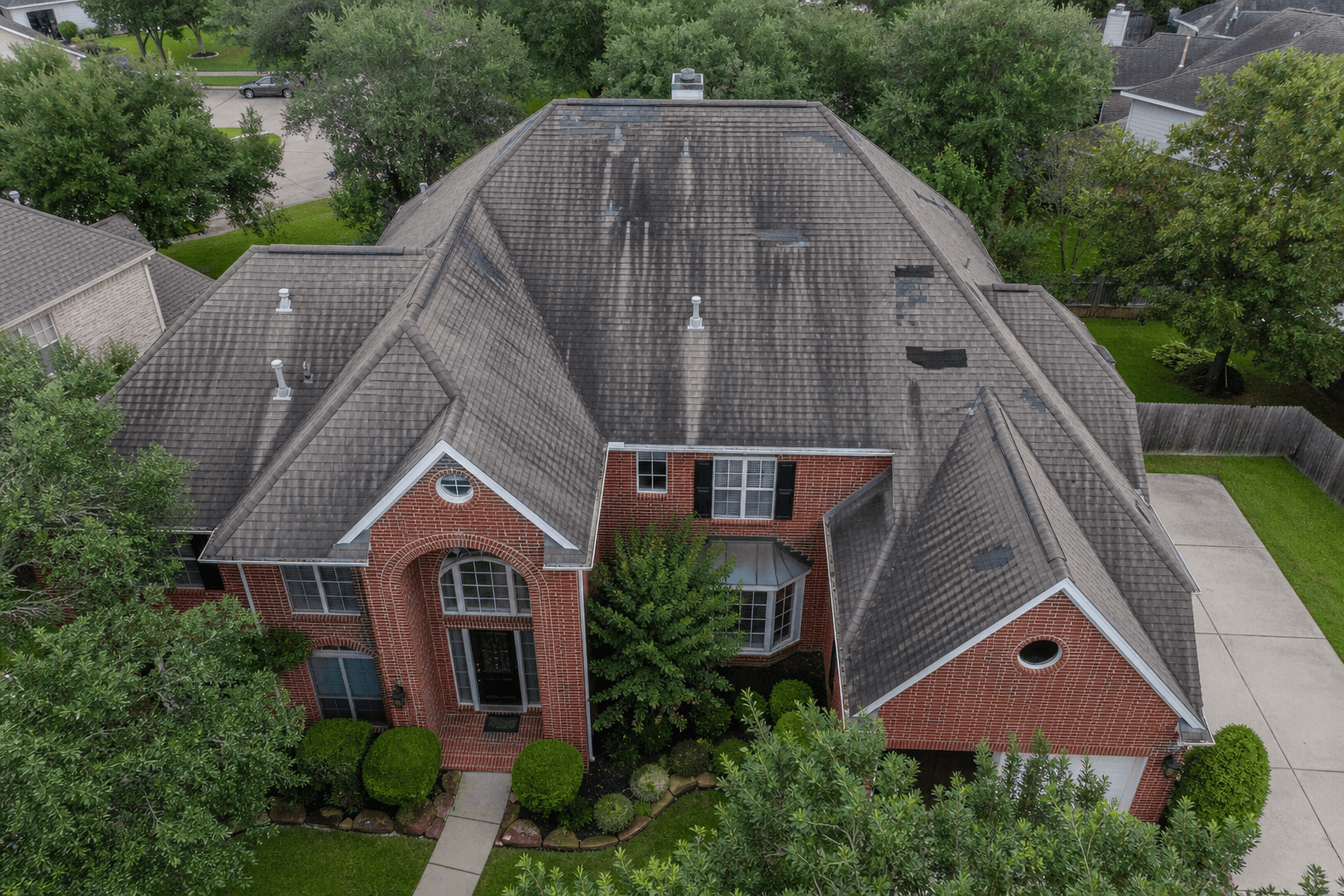 Aging, weathered roof on a Houston home before replacement by Texas Premier Contractors